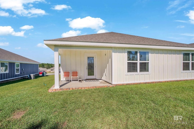 back of property with a patio area and a yard