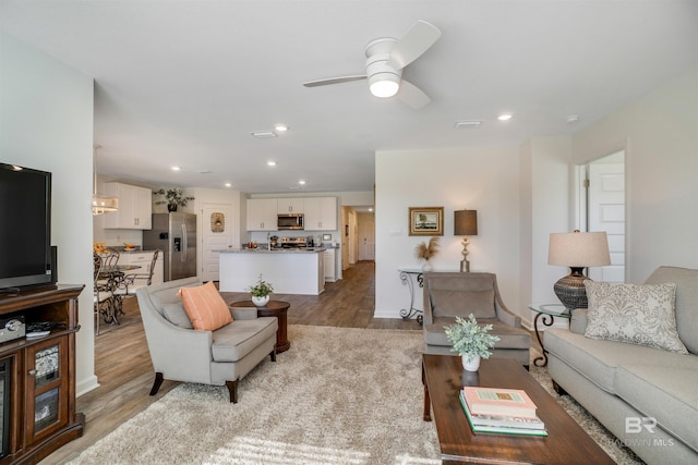 living room featuring ceiling fan and light wood-type flooring