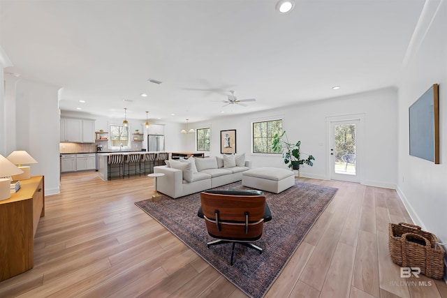 living room with visible vents, baseboards, ceiling fan, light wood-style floors, and recessed lighting