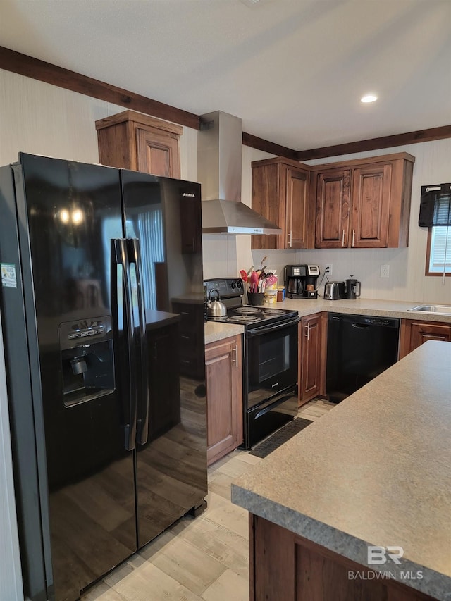 kitchen with wall chimney exhaust hood, light wood-type flooring, black appliances, ornamental molding, and sink