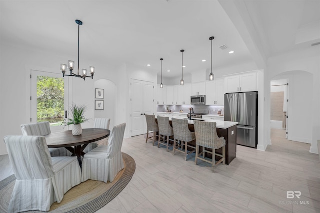 7056 Stone Chase Ln, Gulf Shores, AL 36542 - dining area with arched walkways, an inviting chandelier, visible vents, and recessed lighting