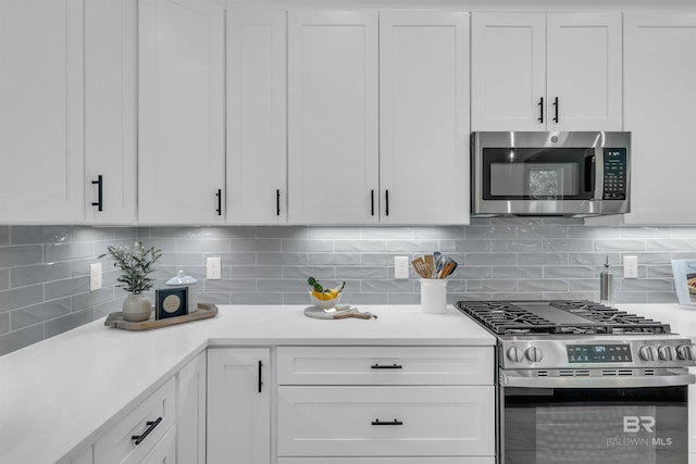 7056 Stone Chase Ln, Gulf Shores, AL 36542 - kitchen with white cabinets, light countertops, backsplash, and appliances with stainless steel finishes