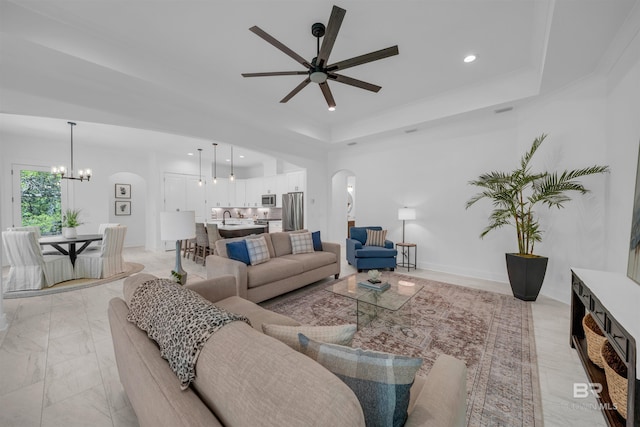 7056 Stone Chase Ln, Gulf Shores, AL 36542 - living area featuring arched walkways, a tray ceiling, recessed lighting, and ceiling fan with notable chandelier