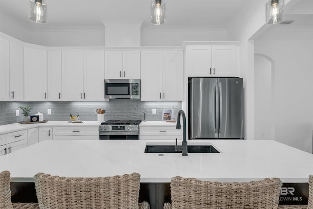 7056 Stone Chase Ln, Gulf Shores, AL 36542 - kitchen featuring white cabinets, a kitchen island with sink, a sink, light countertops, and appliances with stainless steel finishes