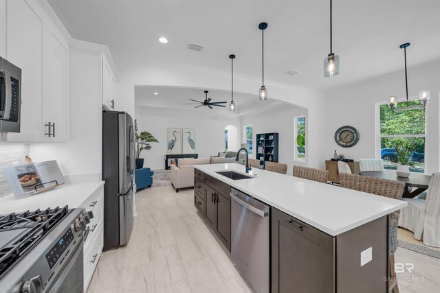 7056 Stone Chase Ln, Gulf Shores, AL 36542 - kitchen featuring a ceiling fan, a sink, open floor plan, stainless steel appliances, and white cabinets
