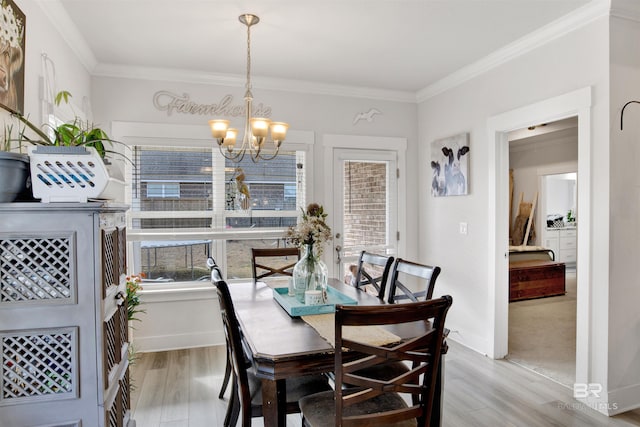 dining area with crown molding, a chandelier, and light wood-type flooring