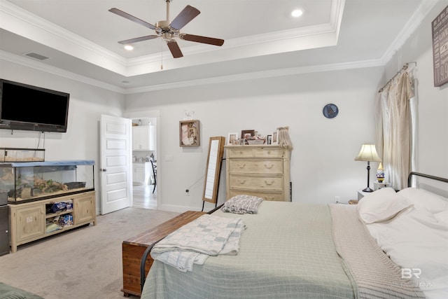 bedroom featuring a tray ceiling, carpet floors, ornamental molding, and ceiling fan