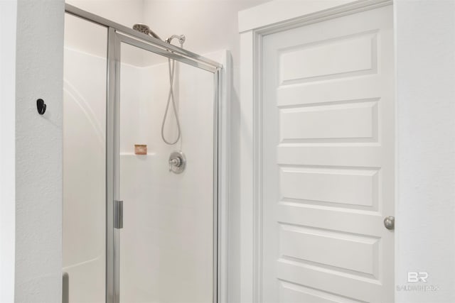 bathroom with a shower with door