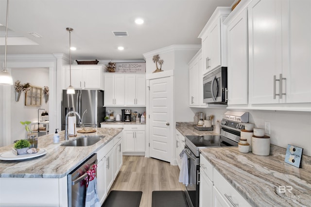 kitchen featuring hanging light fixtures, appliances with stainless steel finishes, white cabinets, and light stone counters