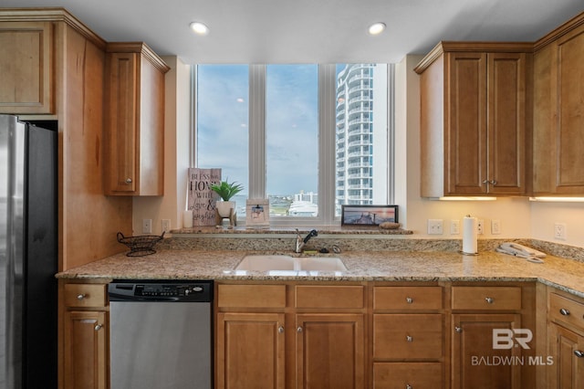 kitchen featuring light stone countertops, sink, and appliances with stainless steel finishes