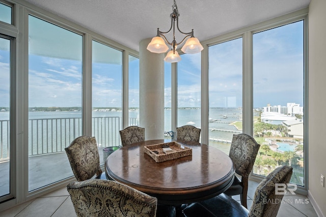 sunroom with a water view and a notable chandelier