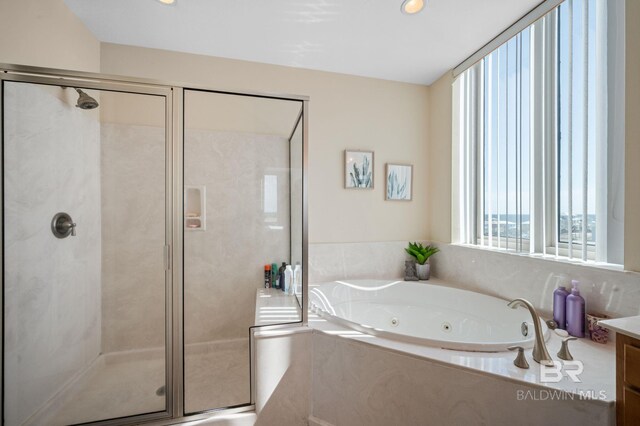 bathroom featuring vanity and independent shower and bath