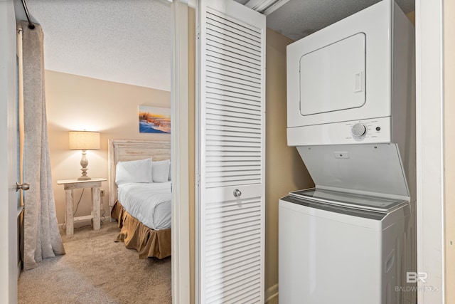 24230 Perdido Beach Blvd Unit 3014, Orange Beach, AL 36561 - laundry room with stacked washer and clothes dryer, carpet floors, and a textured ceiling