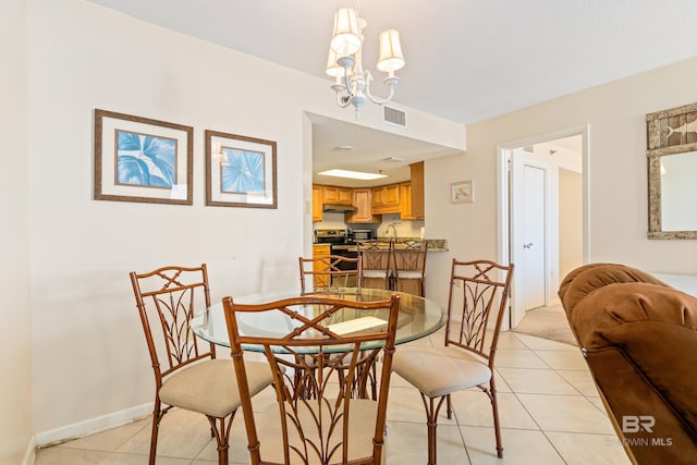 24230 Perdido Beach Blvd Unit 3014, Orange Beach, AL 36561 - dining area featuring light tile patterned floors, a chandelier, and baseboards