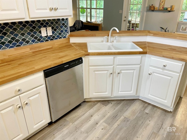 kitchen featuring white cabinetry, sink, wood counters, stainless steel dishwasher, and kitchen peninsula