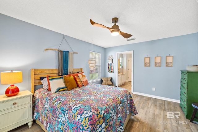 bedroom featuring light wood-type flooring, ensuite bathroom, and ceiling fan