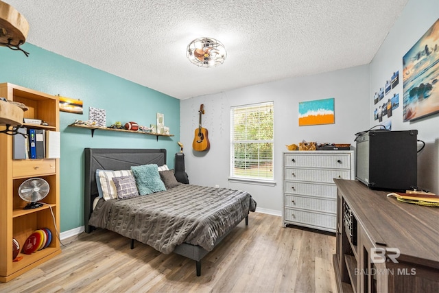 bedroom featuring a textured ceiling and light wood-type flooring