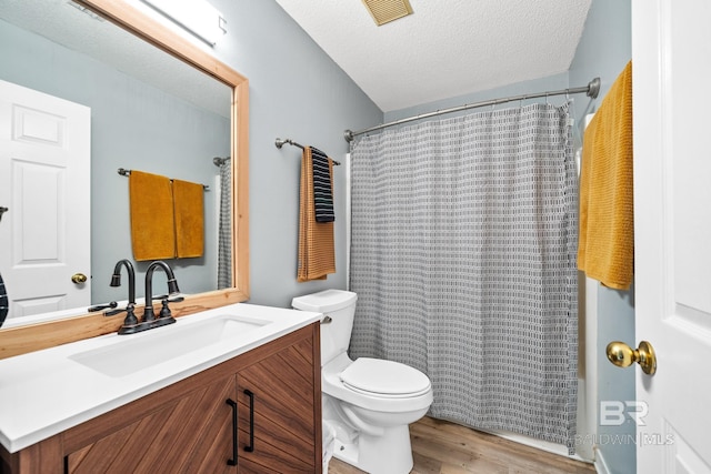 bathroom with vanity, hardwood / wood-style flooring, toilet, a textured ceiling, and walk in shower