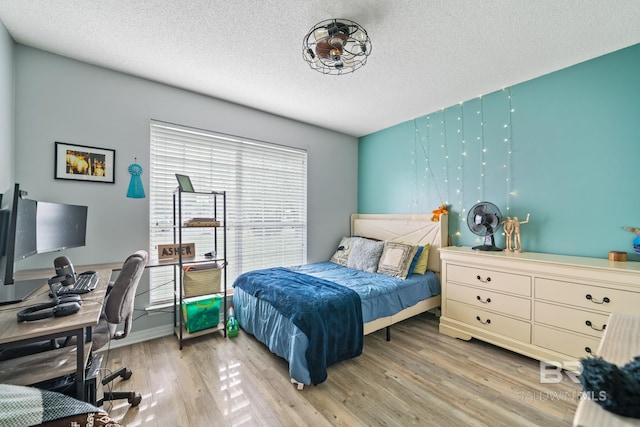 bedroom featuring wood-type flooring and a textured ceiling