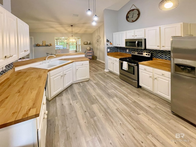 kitchen with wooden counters, white cabinets, sink, appliances with stainless steel finishes, and decorative light fixtures