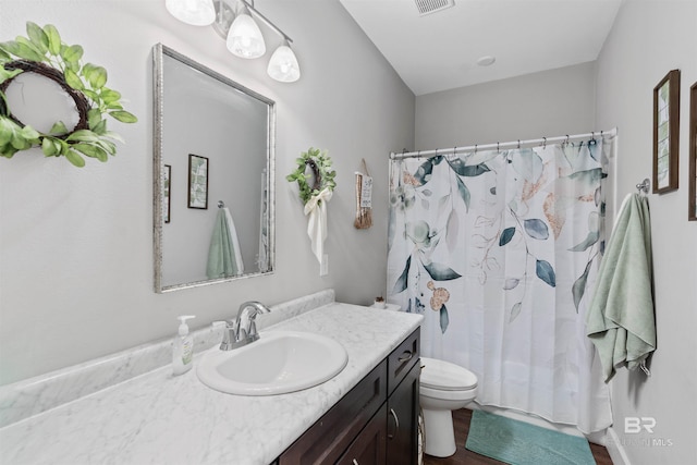 bathroom featuring walk in shower, wood-type flooring, toilet, and vanity