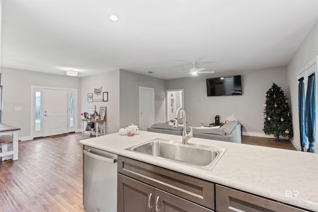 kitchen featuring stainless steel dishwasher, sink, ceiling fan, and light wood-type flooring