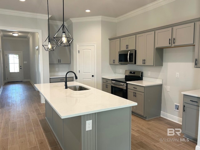 kitchen with sink, gray cabinetry, hanging light fixtures, a kitchen island with sink, and stainless steel appliances