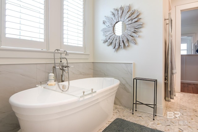 bathroom featuring a bath and tile walls