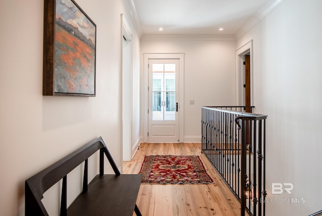 doorway to outside featuring crown molding and light hardwood / wood-style floors