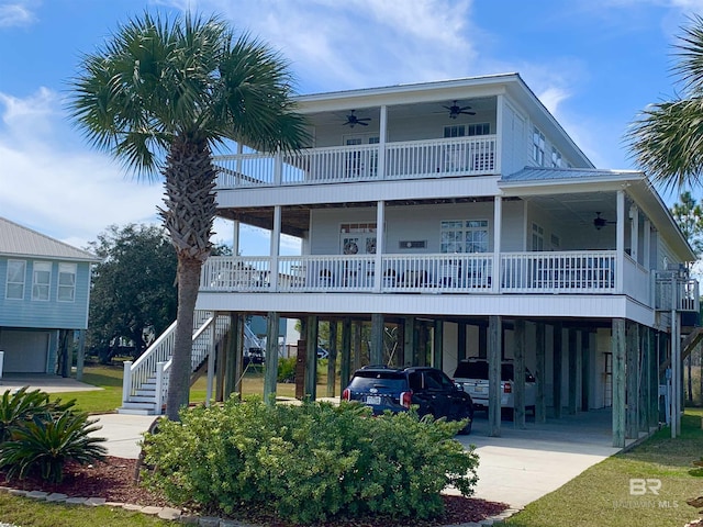 view of front of house featuring driveway, ceiling fan, stairway, and a carport