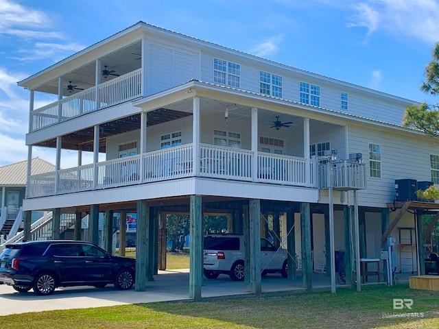 exterior space with a carport, concrete driveway, ceiling fan, and stairs