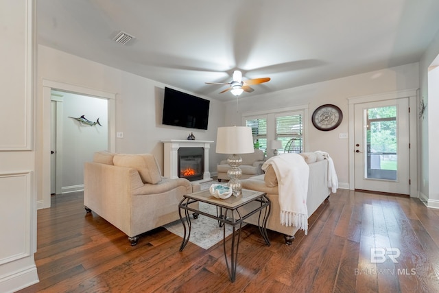 living room with ceiling fan and dark hardwood / wood-style flooring