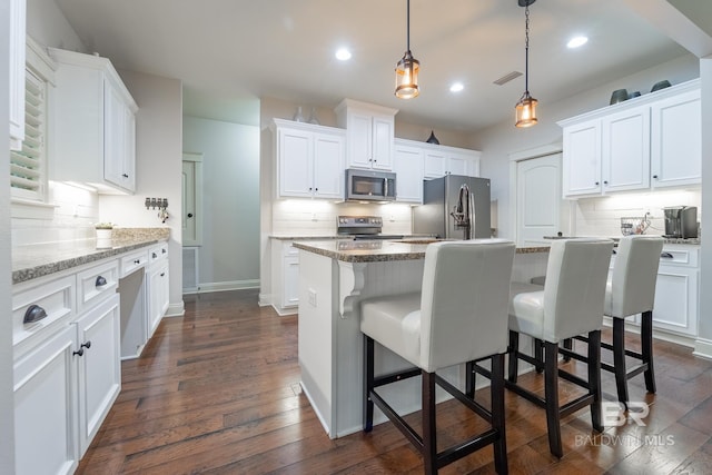 kitchen featuring dark wood finished floors, white cabinets, stainless steel appliances, and tasteful backsplash