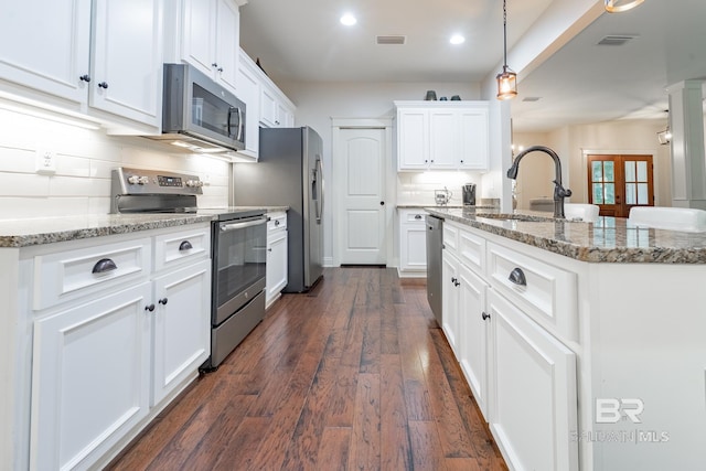 kitchen featuring decorative light fixtures, appliances with stainless steel finishes, dark hardwood / wood-style flooring, white cabinetry, and sink