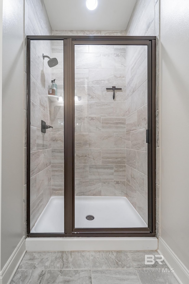 full bath featuring baseboards and a stall shower