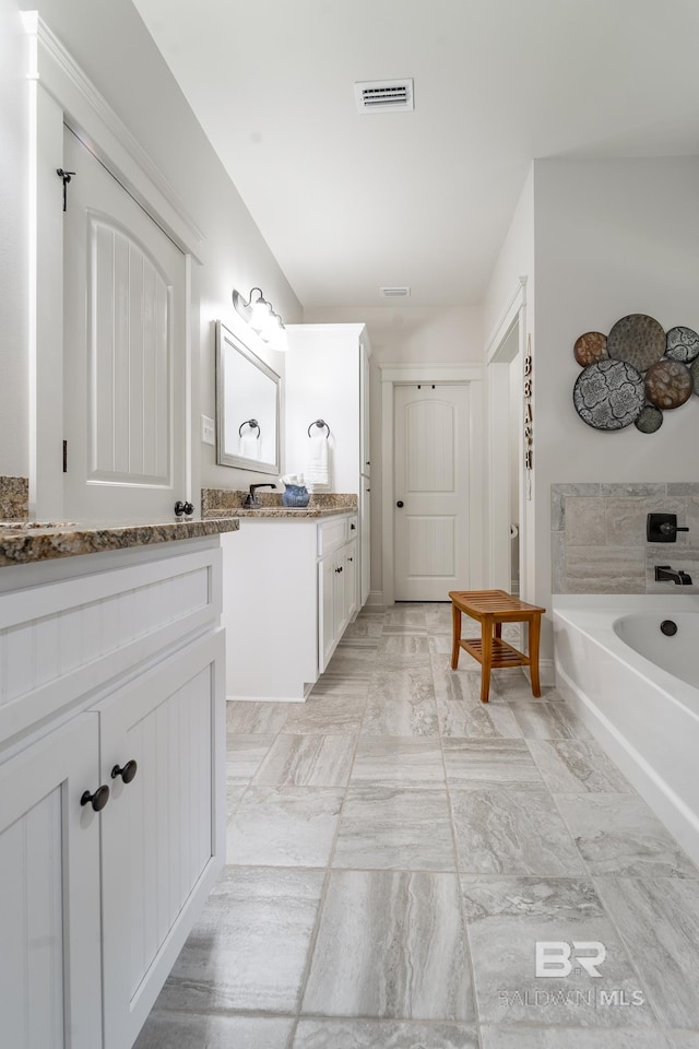 bathroom with vanity and a bath