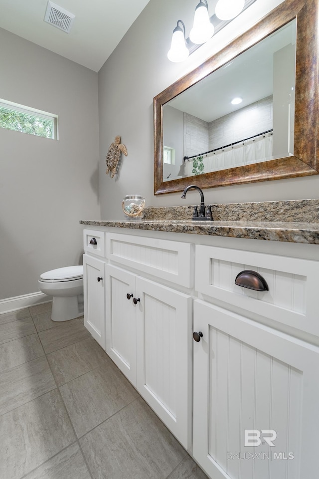 bathroom with vanity, toilet, and tile patterned flooring