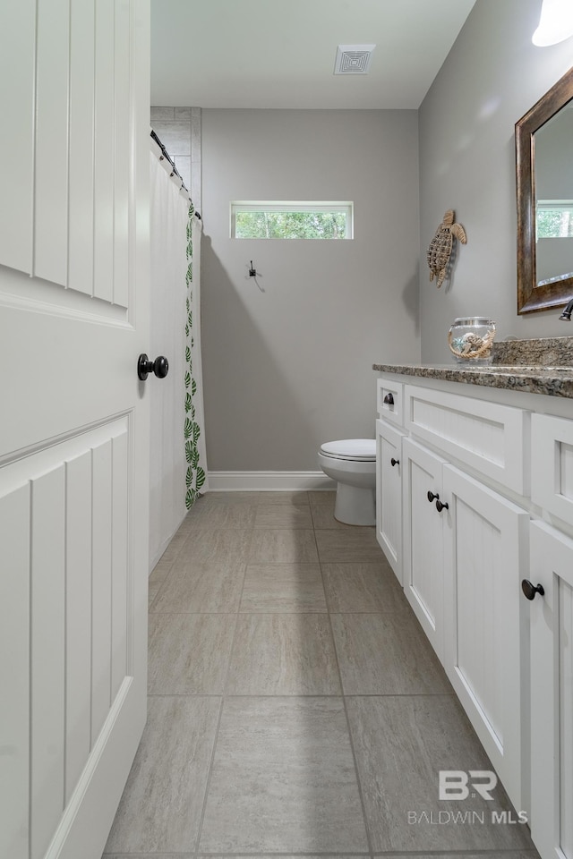 bathroom with vanity, curtained shower, toilet, and visible vents