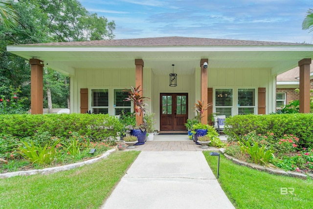 entrance to property featuring a porch, roof with shingles, and board and batten siding