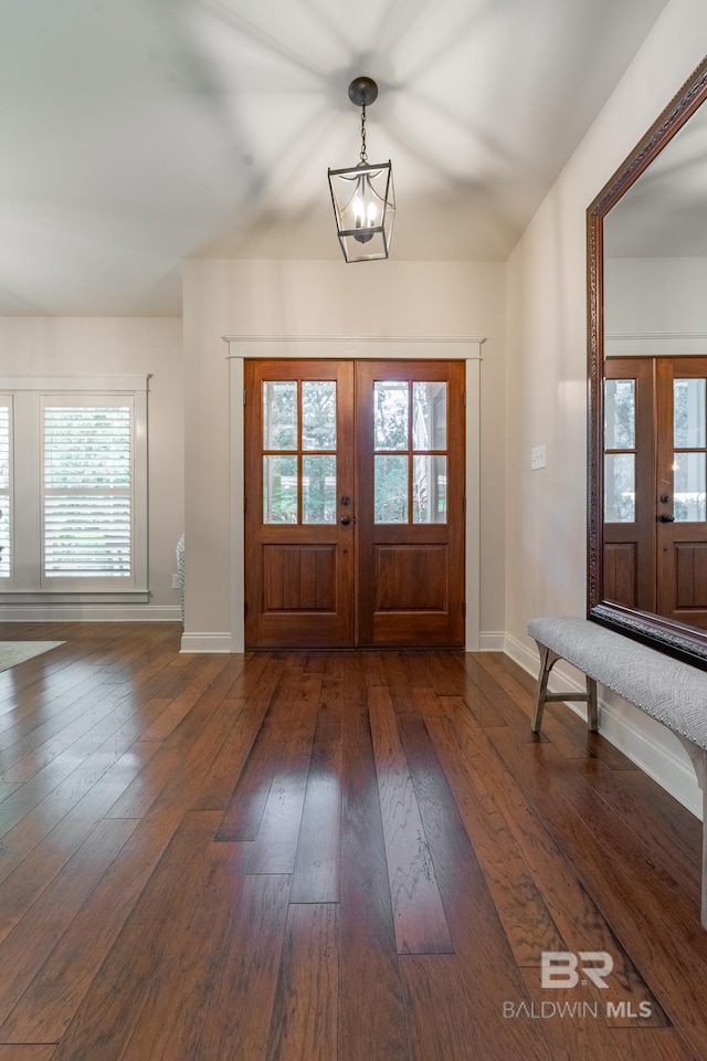 entrance foyer with plenty of natural light, dark hardwood / wood-style floors, a chandelier, and french doors