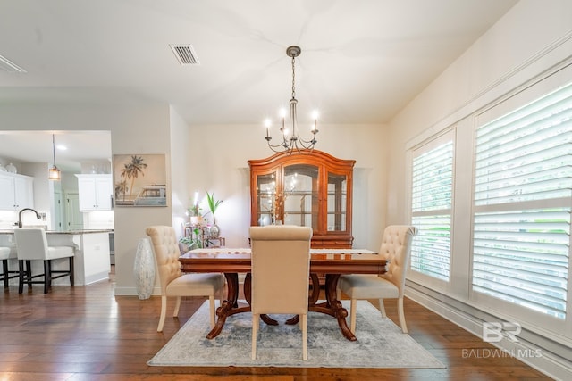 dining room with dark wood finished floors, visible vents, baseboards, and an inviting chandelier