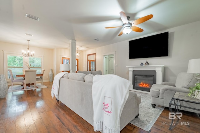 living room featuring ceiling fan with notable chandelier and dark hardwood / wood-style flooring