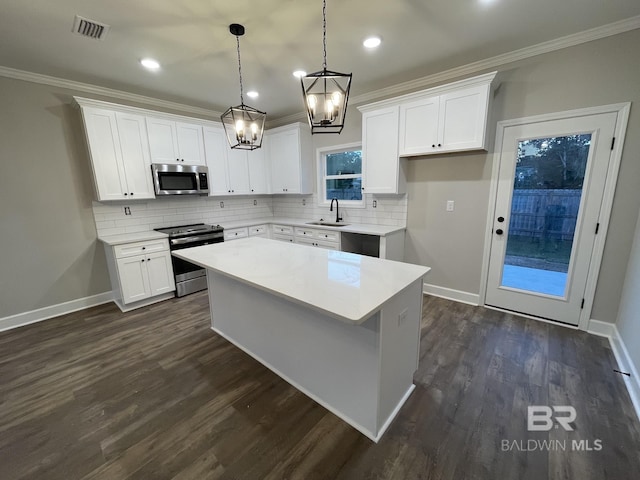 kitchen featuring stainless steel appliances, ornamental molding, a sink, and visible vents