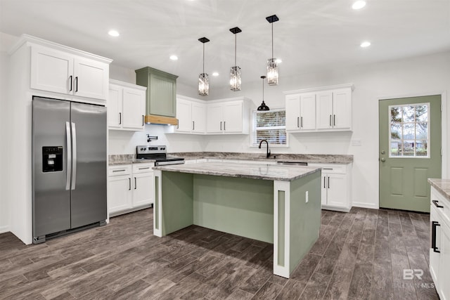 kitchen with stainless steel appliances, a kitchen island, light stone countertops, and decorative light fixtures