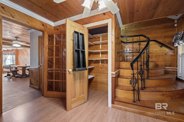 interior space featuring ceiling fan, wooden walls, and wood ceiling