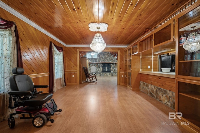 interior space with wood ceiling, crown molding, wood-type flooring, a chandelier, and wooden walls