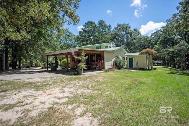 rear view of house featuring a lawn and a carport