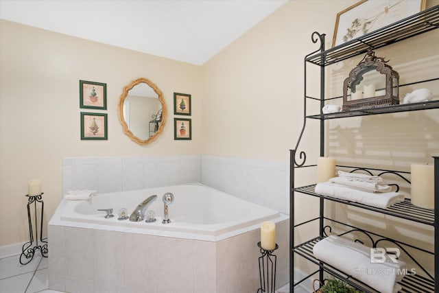 bathroom featuring tiled tub, vaulted ceiling, and tile patterned flooring