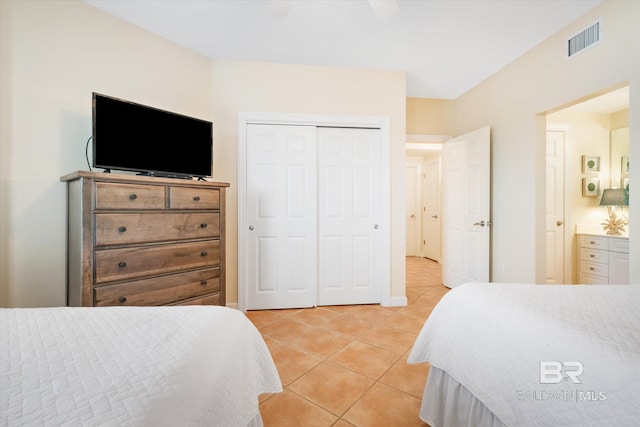 bedroom with ceiling fan, a closet, ensuite bath, and light tile patterned floors