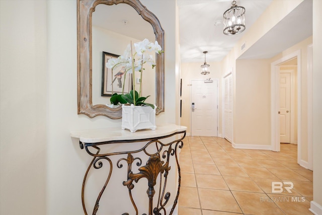 corridor featuring an inviting chandelier and light tile patterned floors